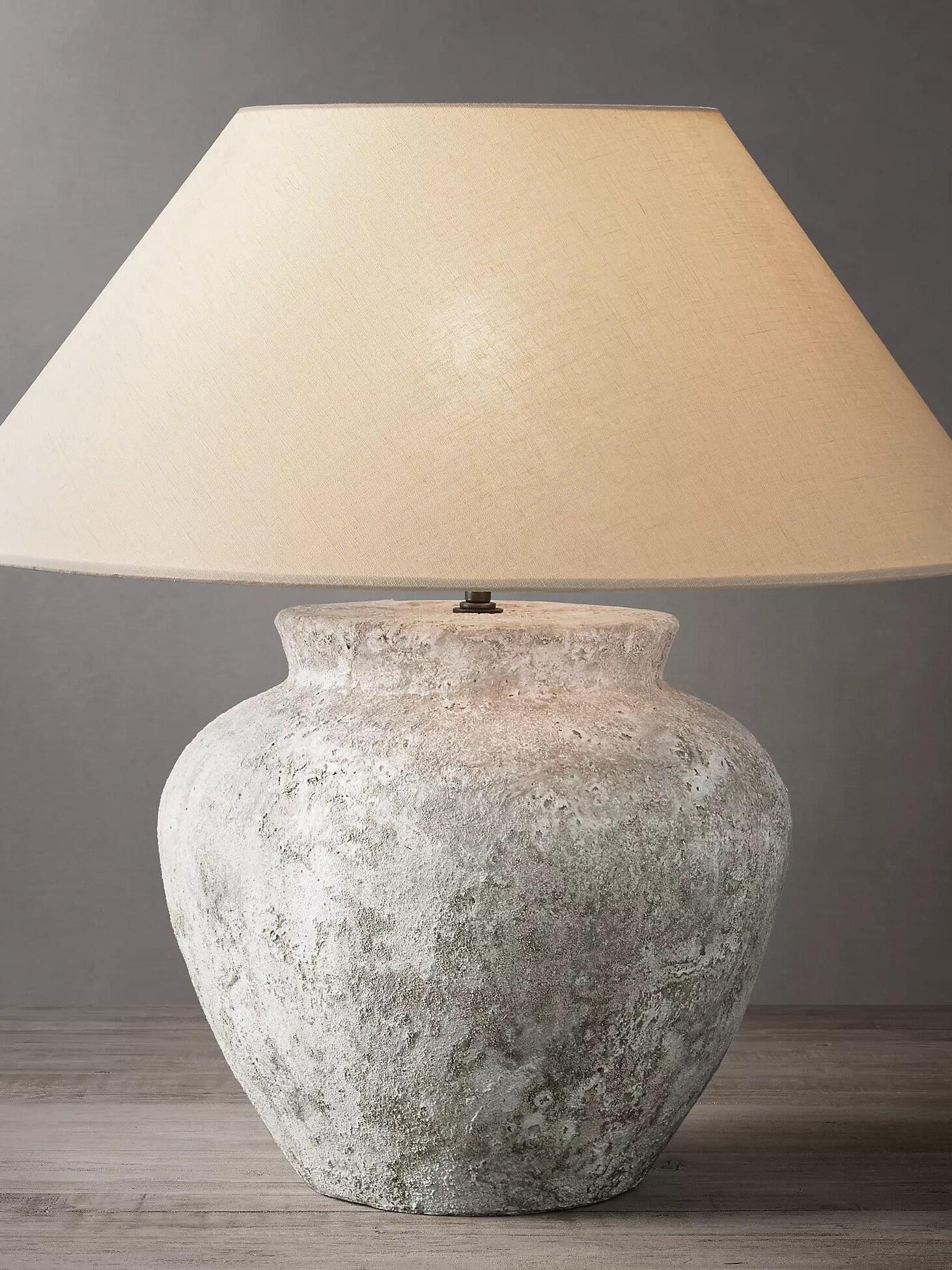 Close view of textured urn base and tapering pale shade