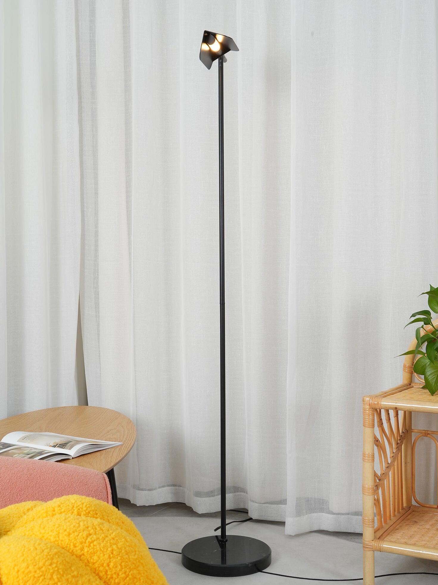 Black floor lamp beside curtains and a small table