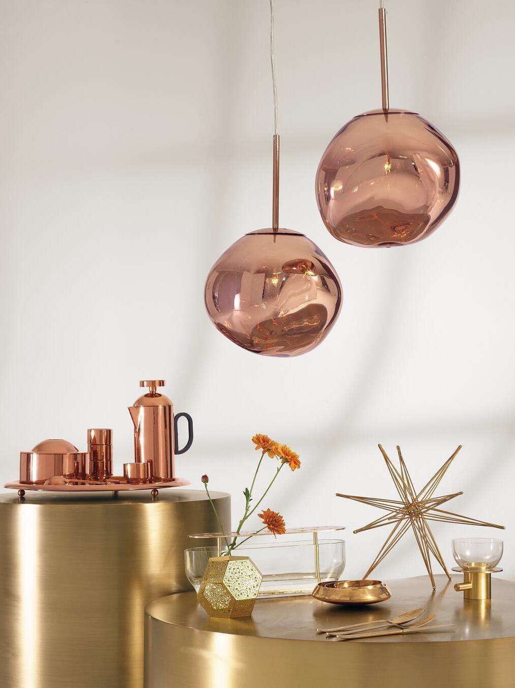 Two copper-toned reflective shades above a cabinet