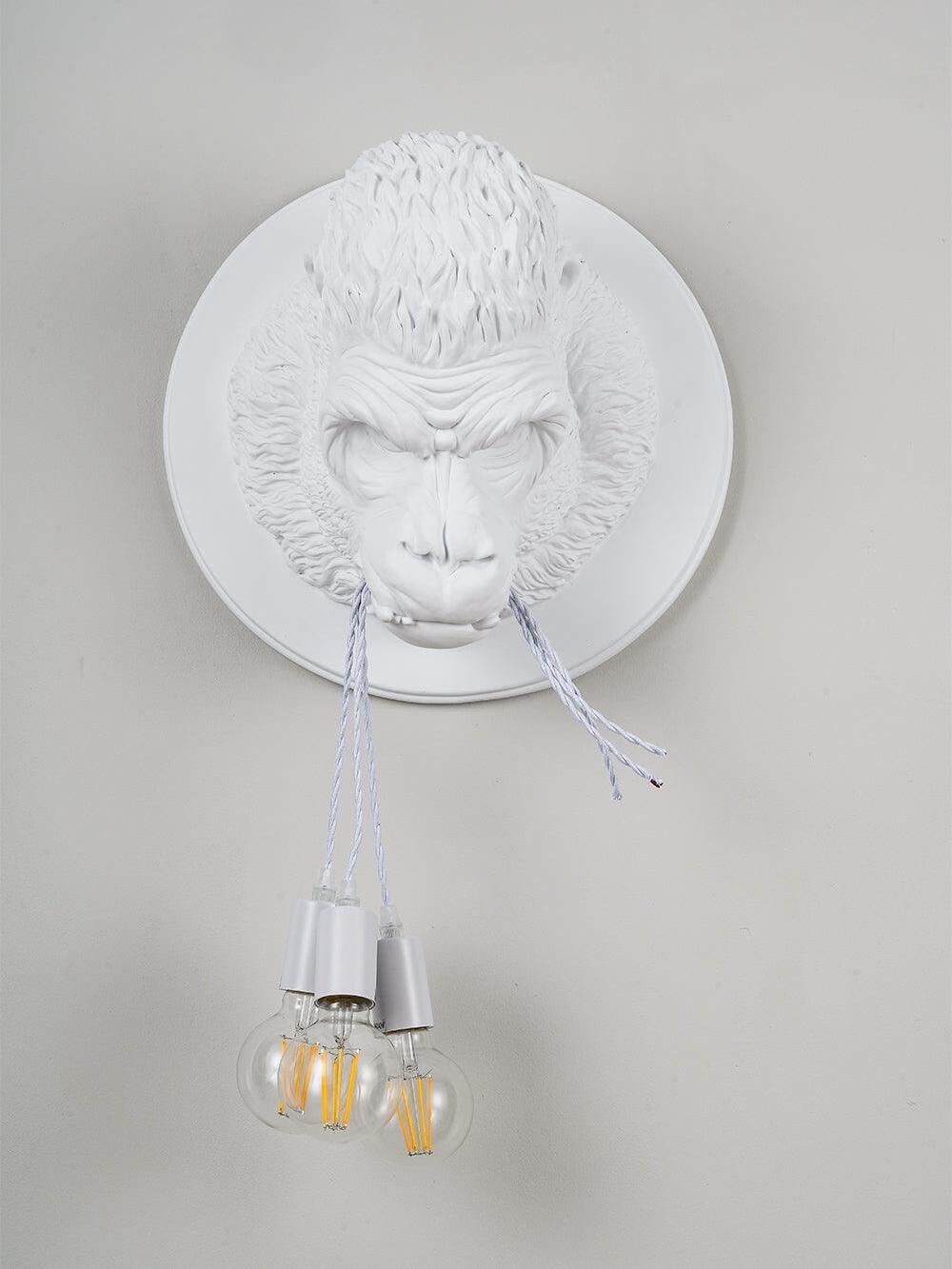 White gorilla relief on pale wall with hanging clear round bulbs