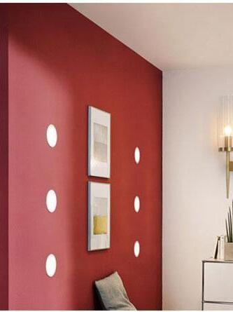 Glass wall sconce at the edge of a red room setting