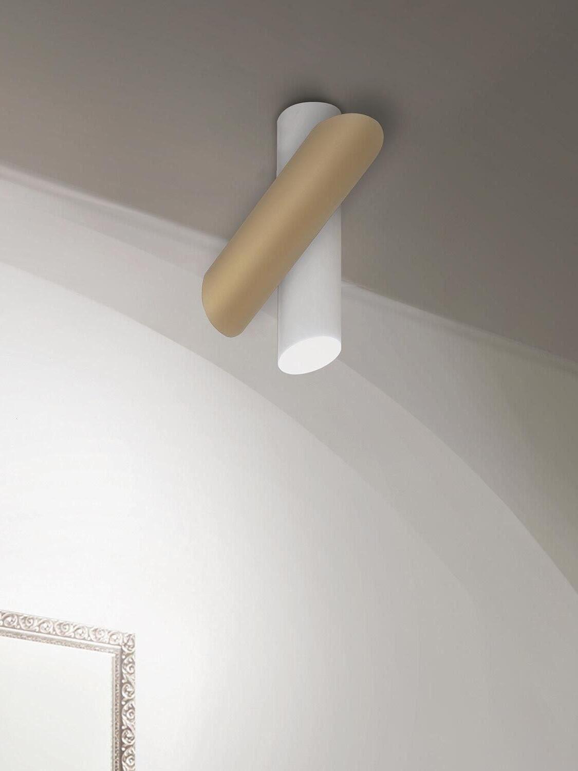 White and gold-tone ceiling fixture near an arched opening and framed wall decoration