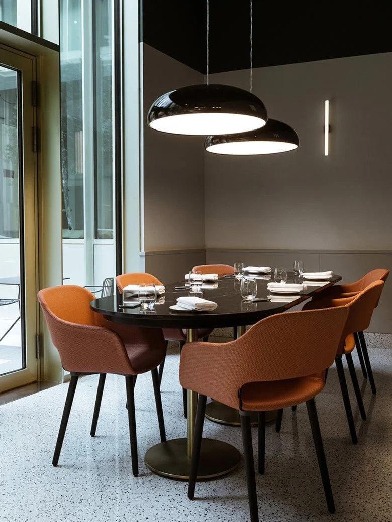 Black dome over a table with orange chairs