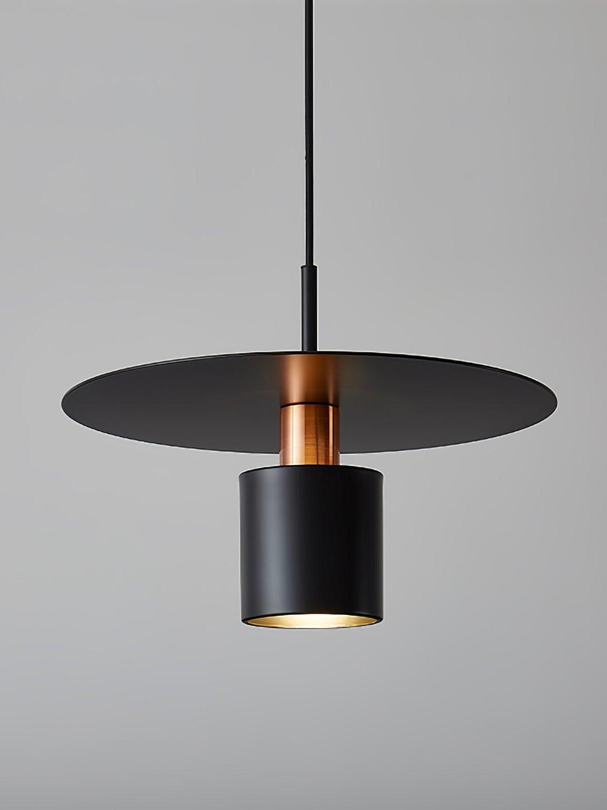 Close black cylinder below wide metal disc