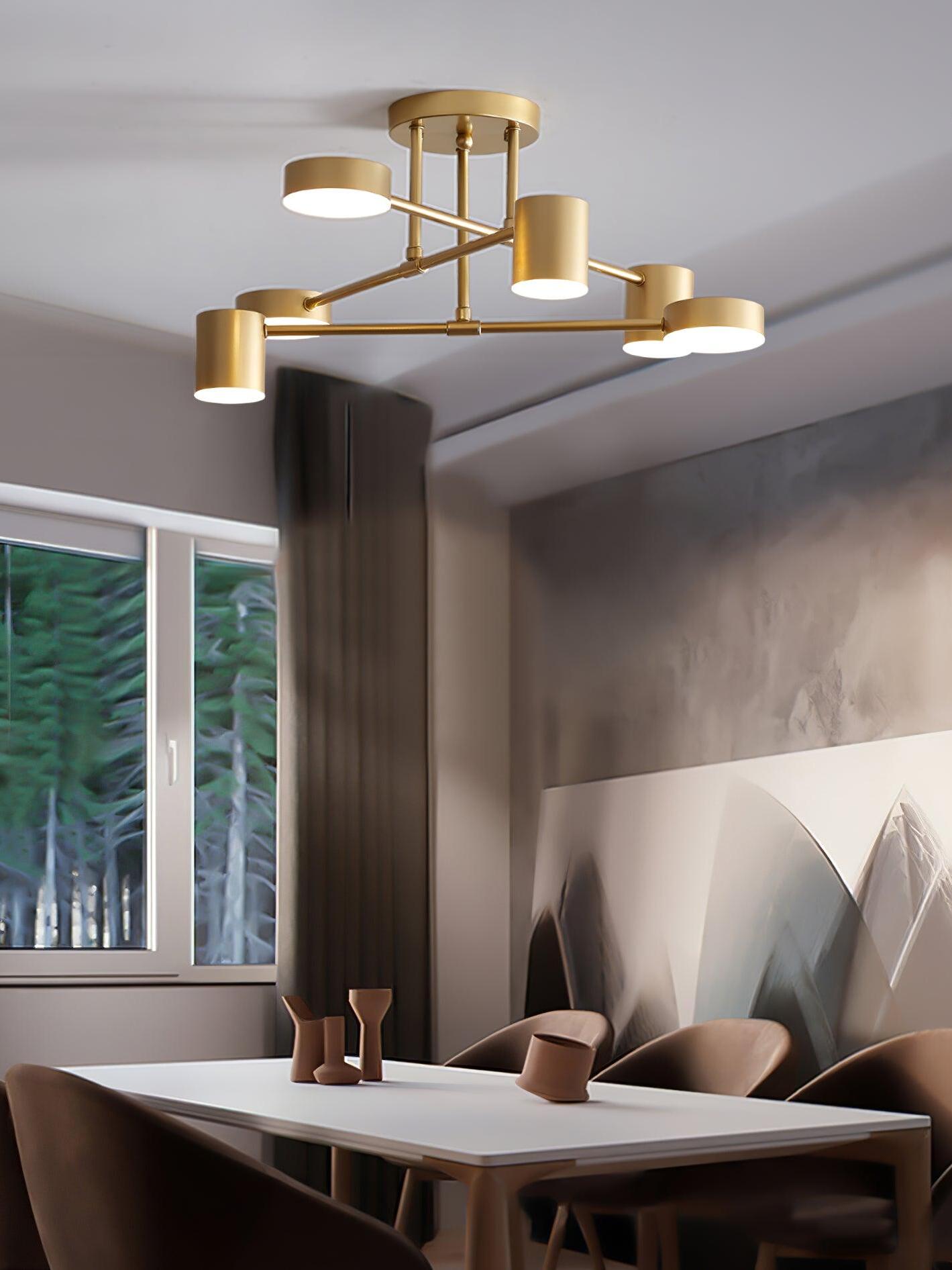 Gold six-head ceiling light above a rectangular dining table with brown chairs, angular vessels and geometric artwork