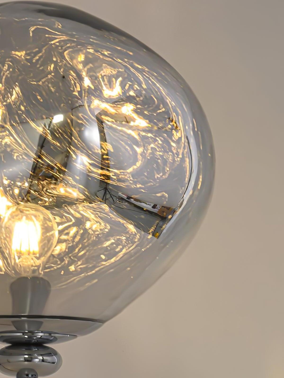 Close view of an illuminated irregular globe shade with a visible bulb and warm-looking reflections