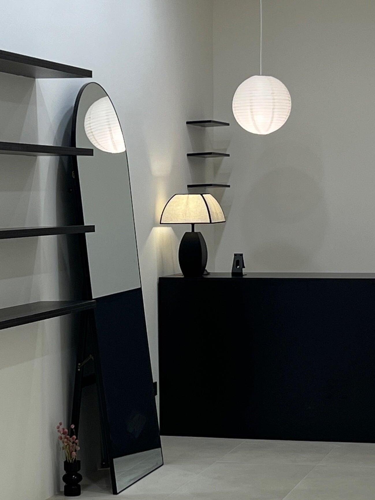 Black-base table lamp lit in small interior