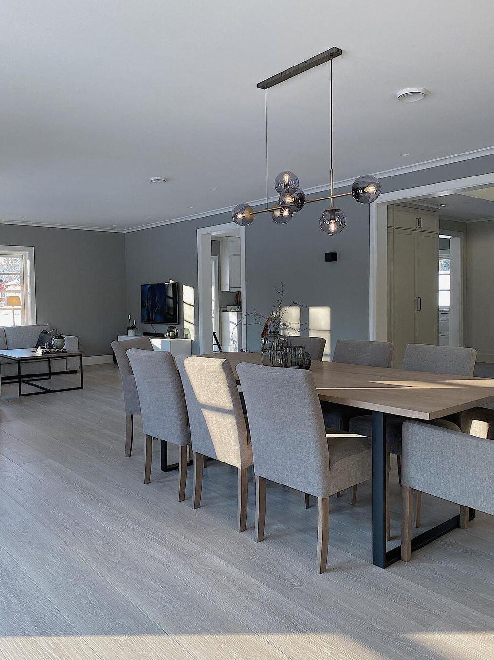 Linear fixture over a table with gray upholstered chairs