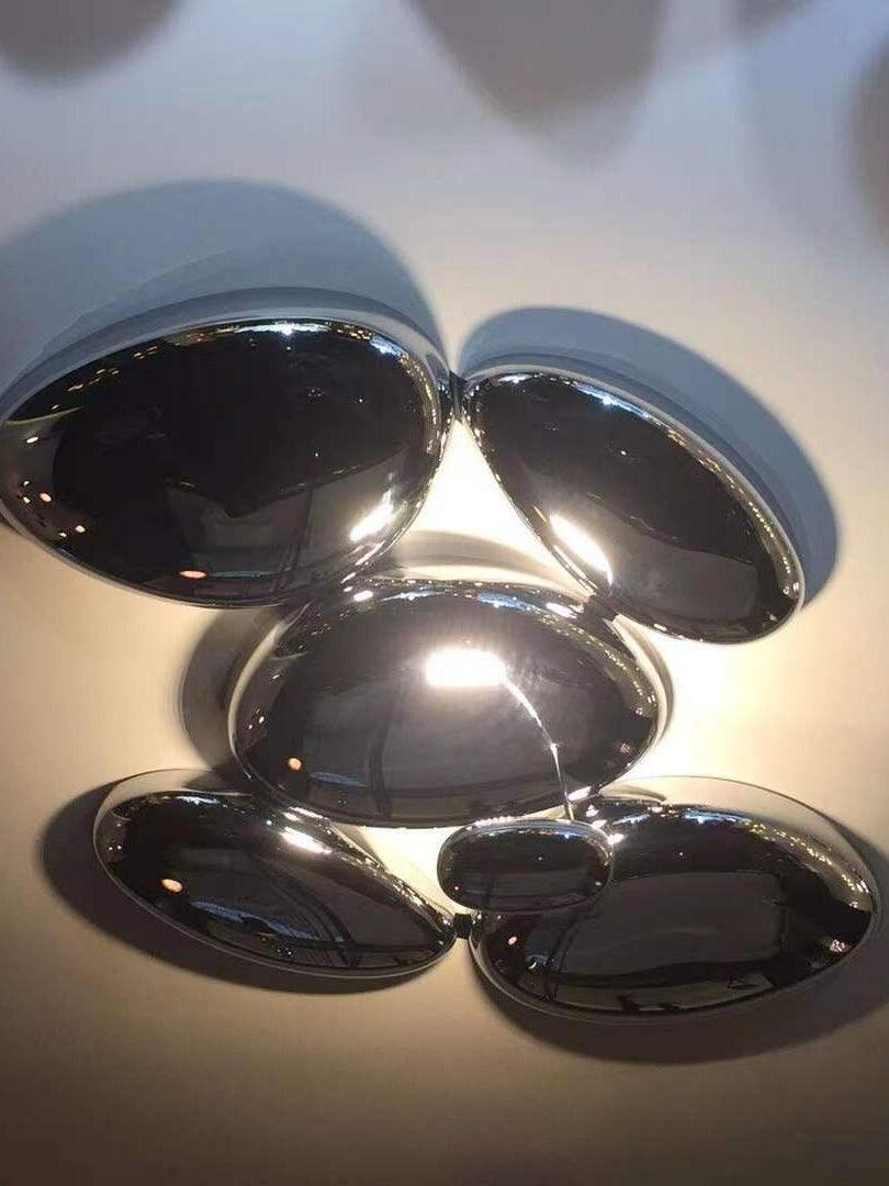 Underside of reflective ceiling cluster with warm glow around rounded forms