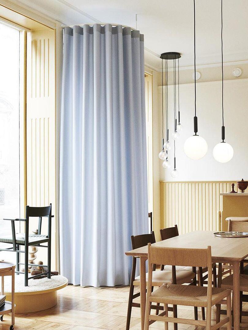 White globes suspended beside dining-room curtains