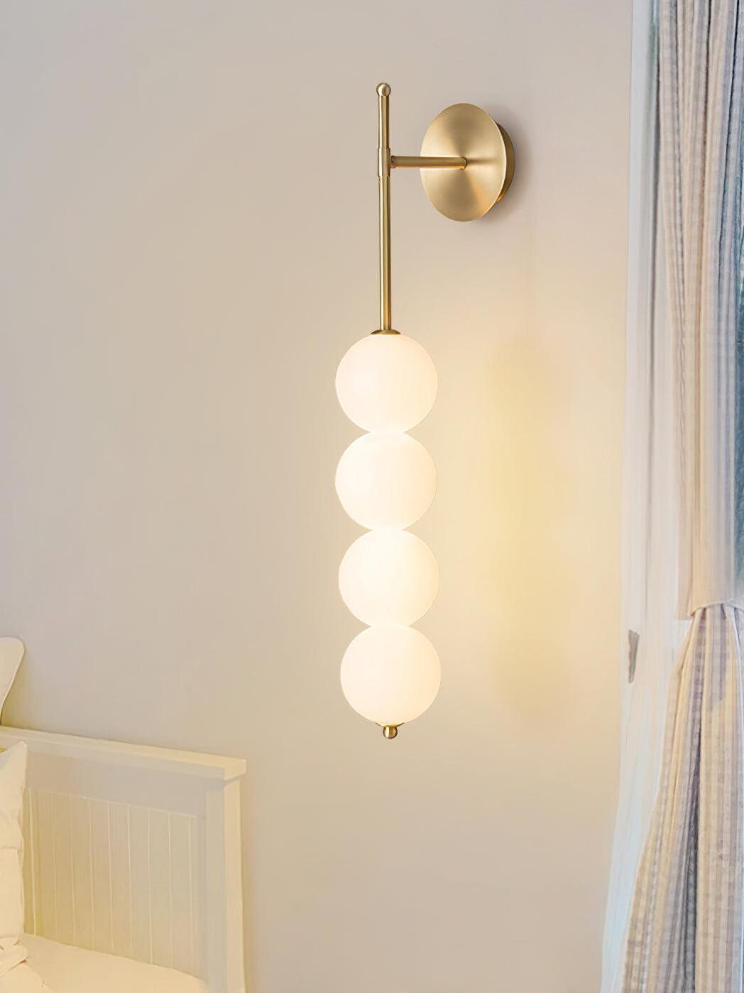 Brass globe wall light beside a window