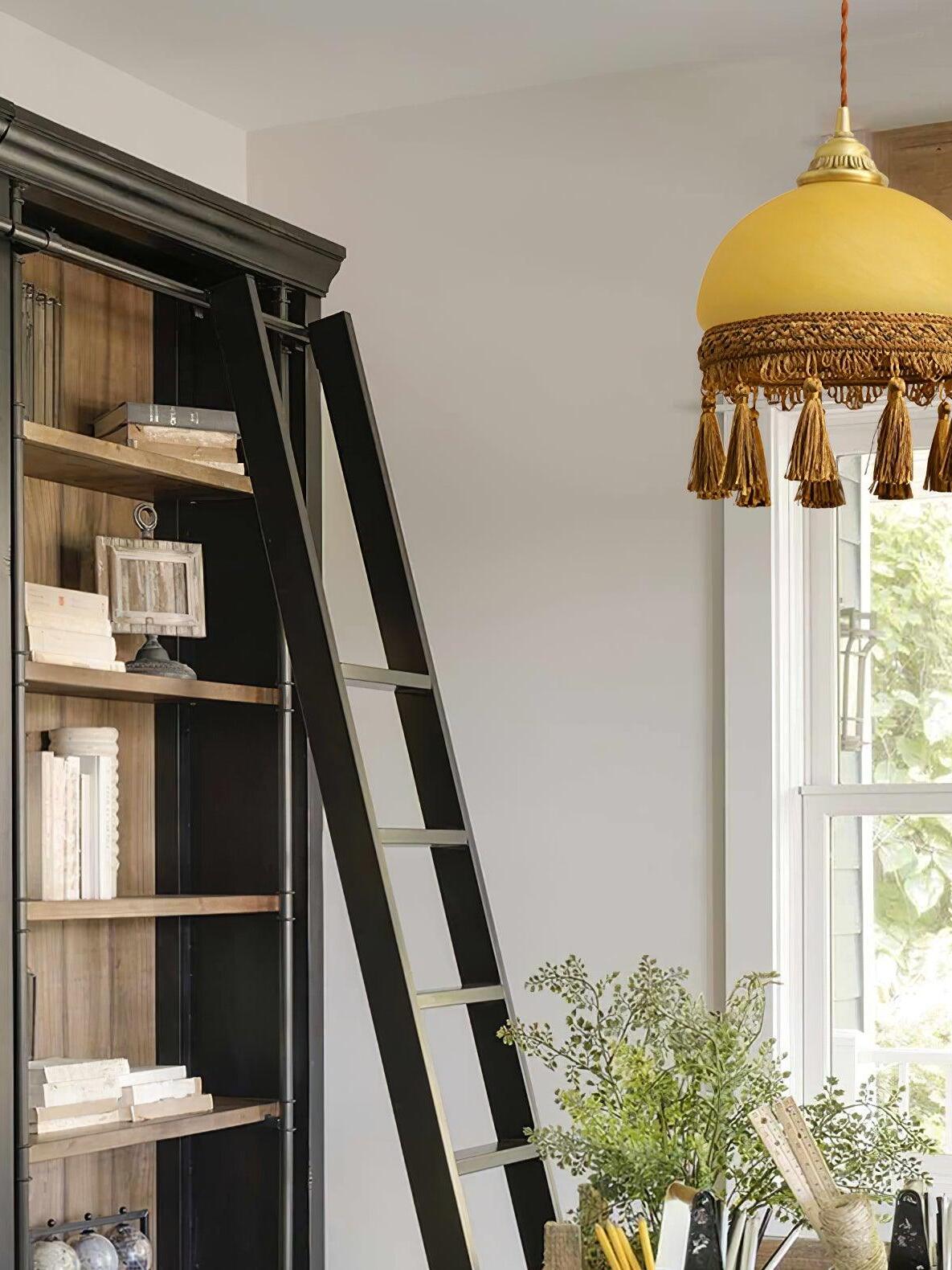 Yellow tassel pendant beside tall bookcase