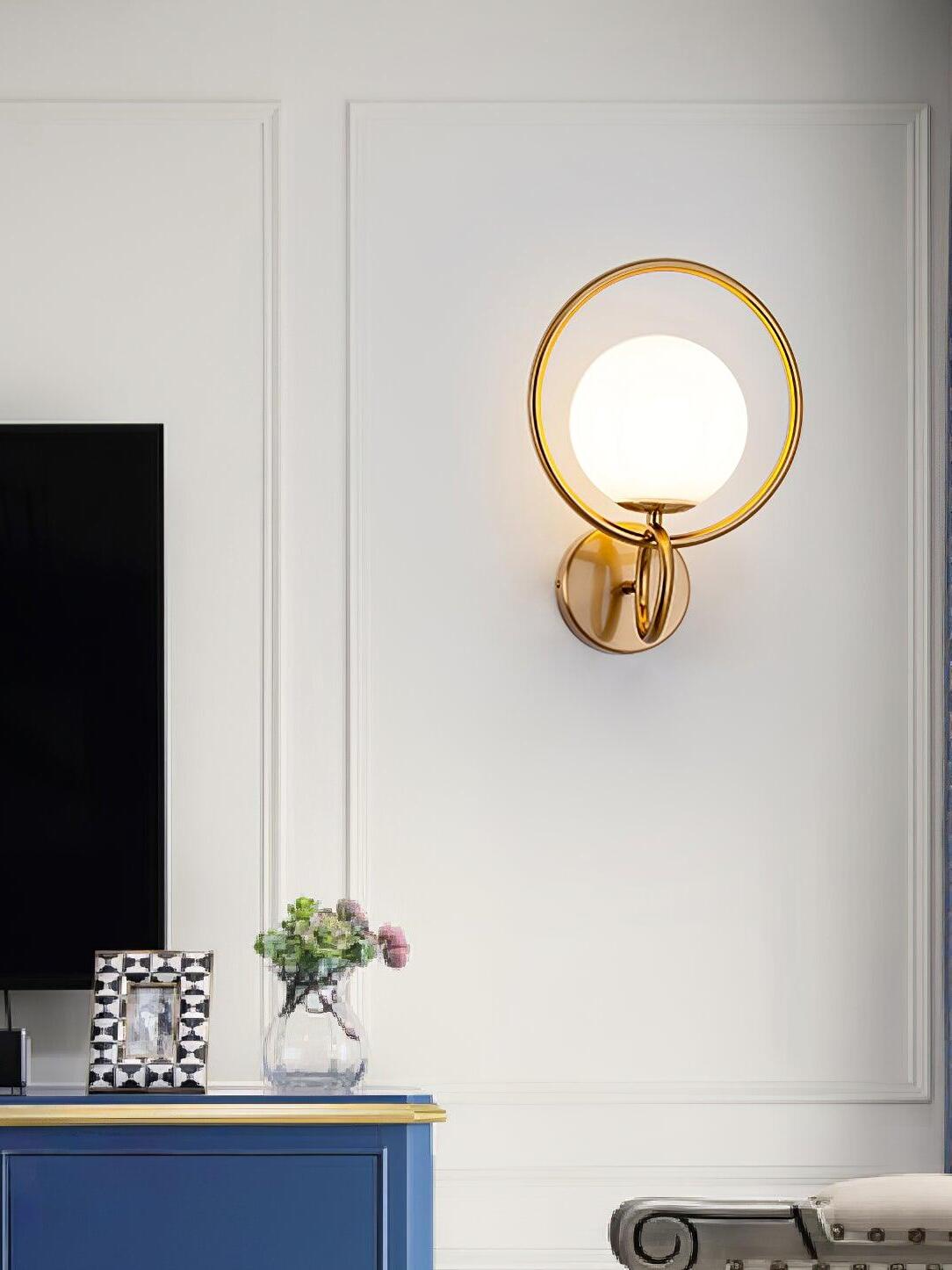 Gold white globe wall lamp near television