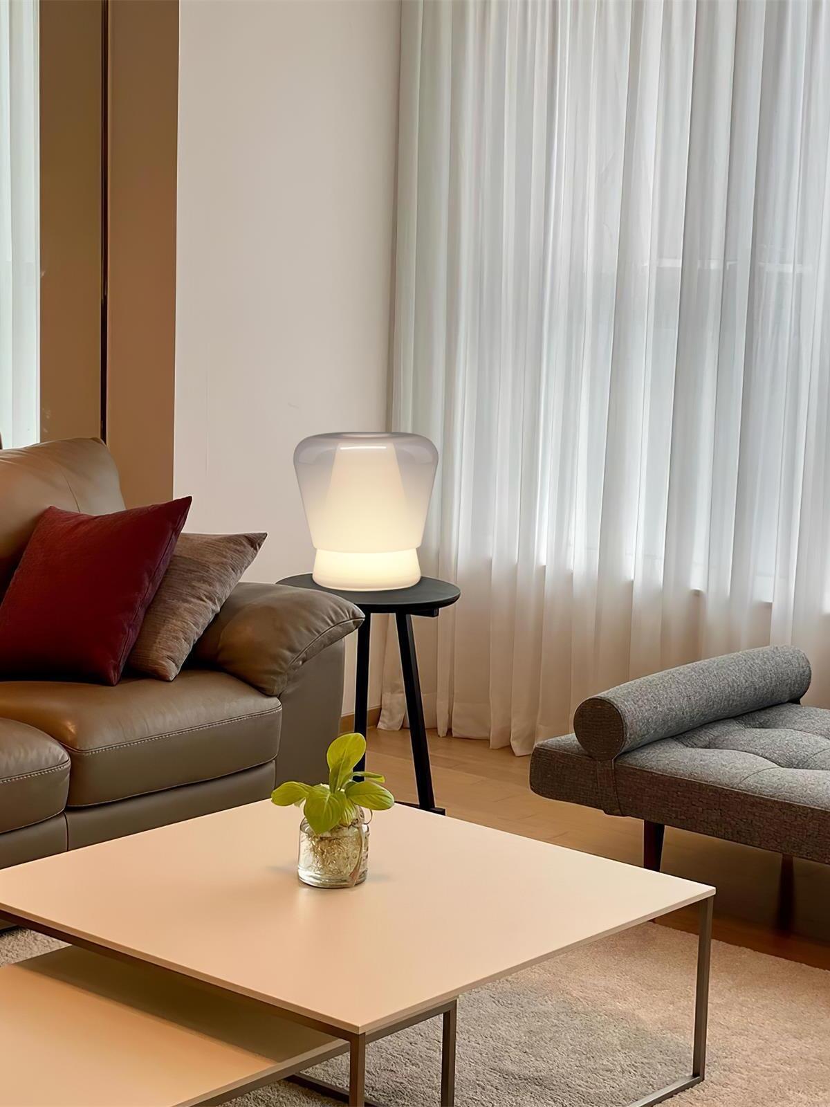 White Jumelle glass lamp beside living room sofa