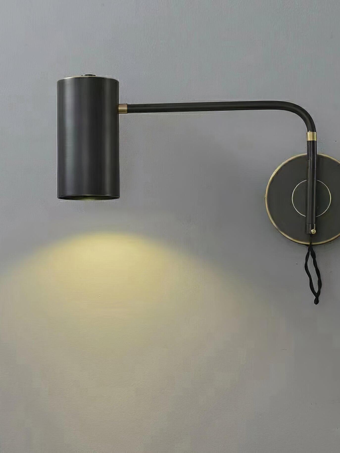 Lit black wall light with gold-tone rims and collars