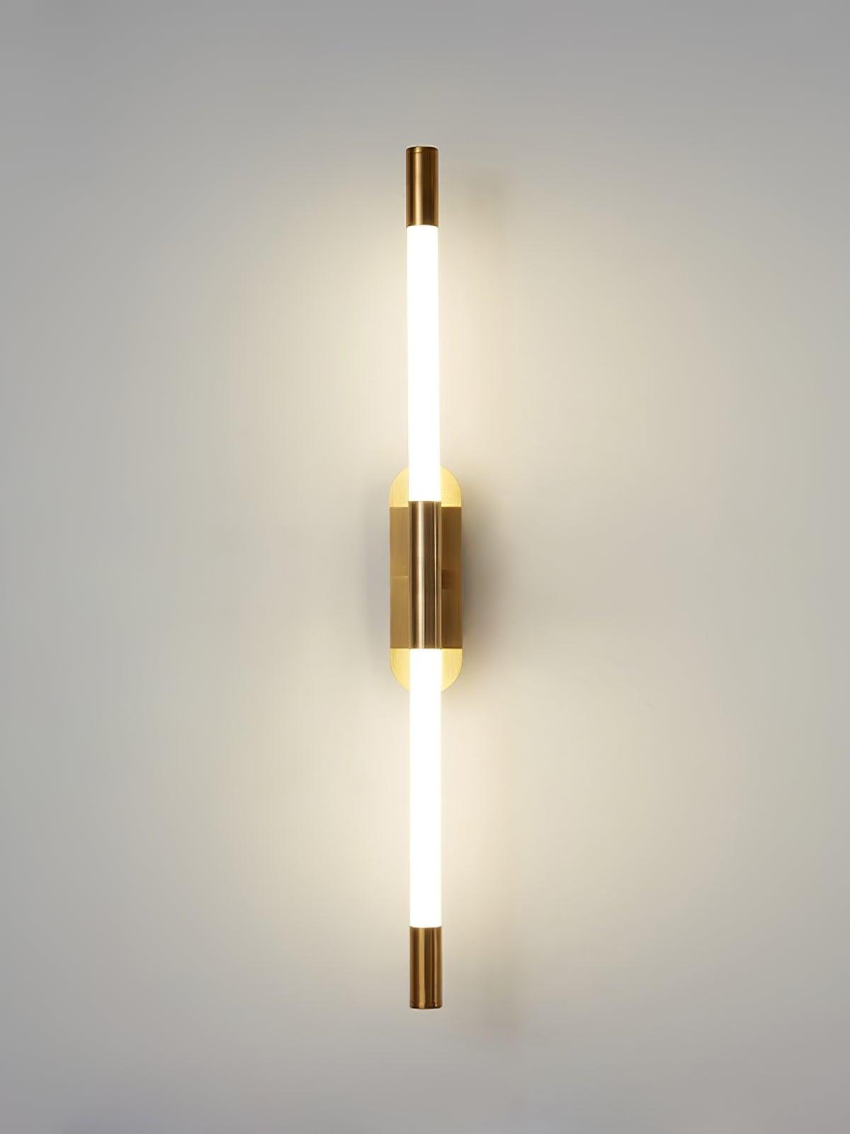 Front view of the glowing gold Agnes wall light with two white tube sections and matching end caps