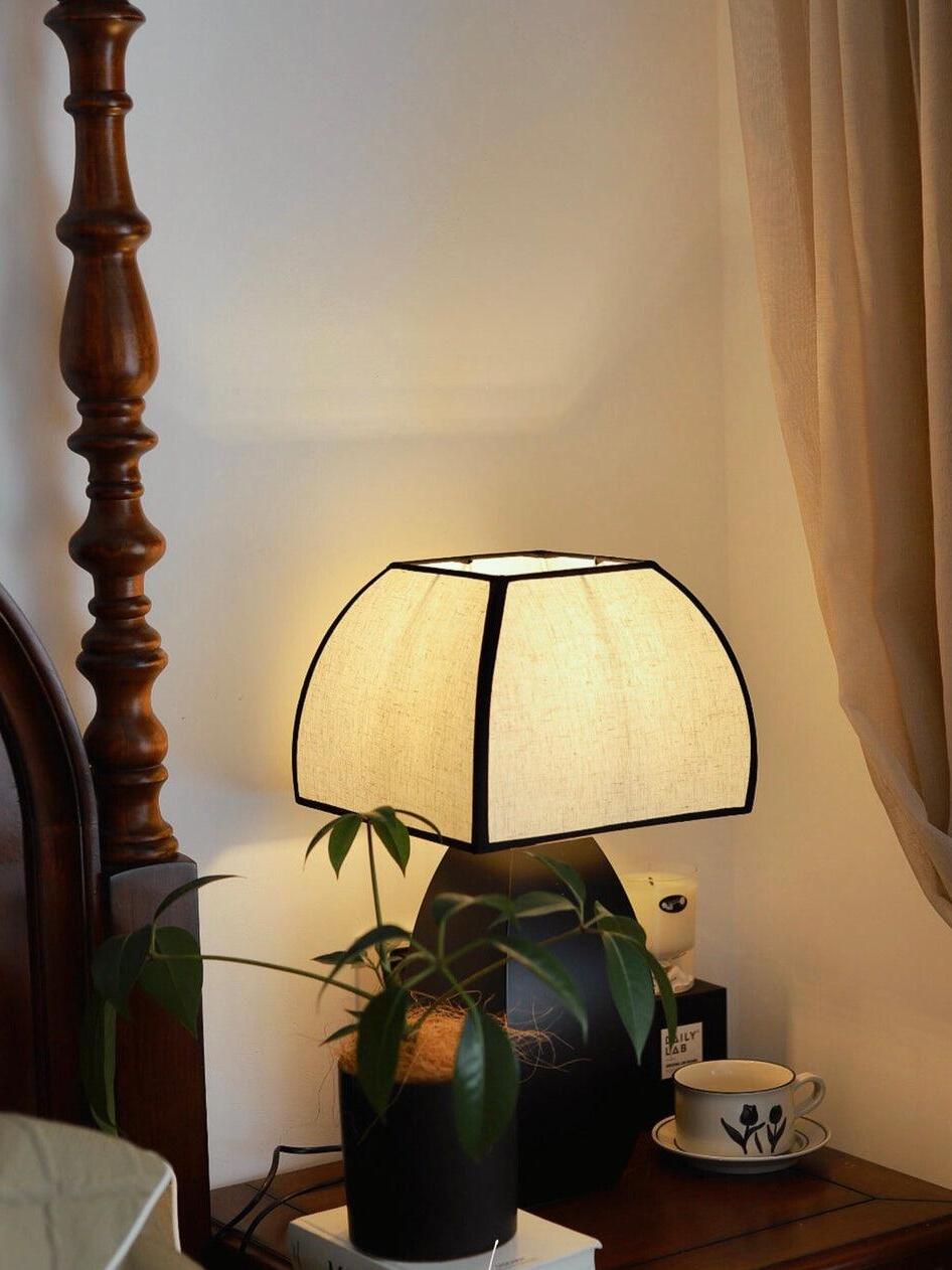 Lit Javier lamp on wooden bedside table