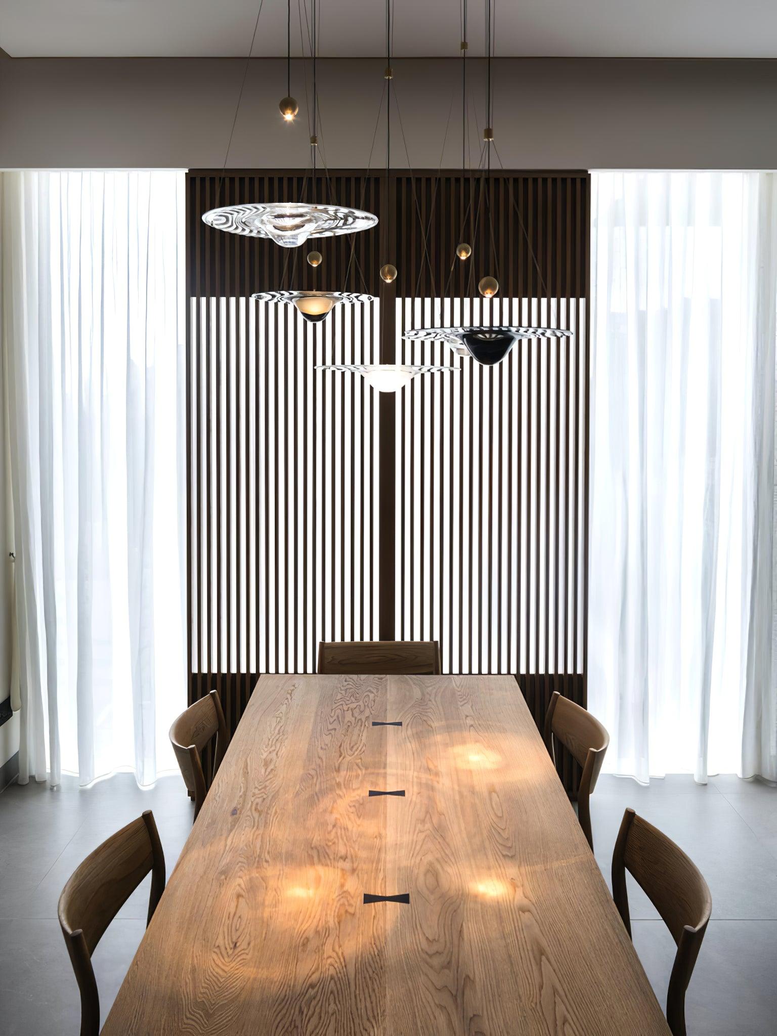 Glass disc pendants above long dining table