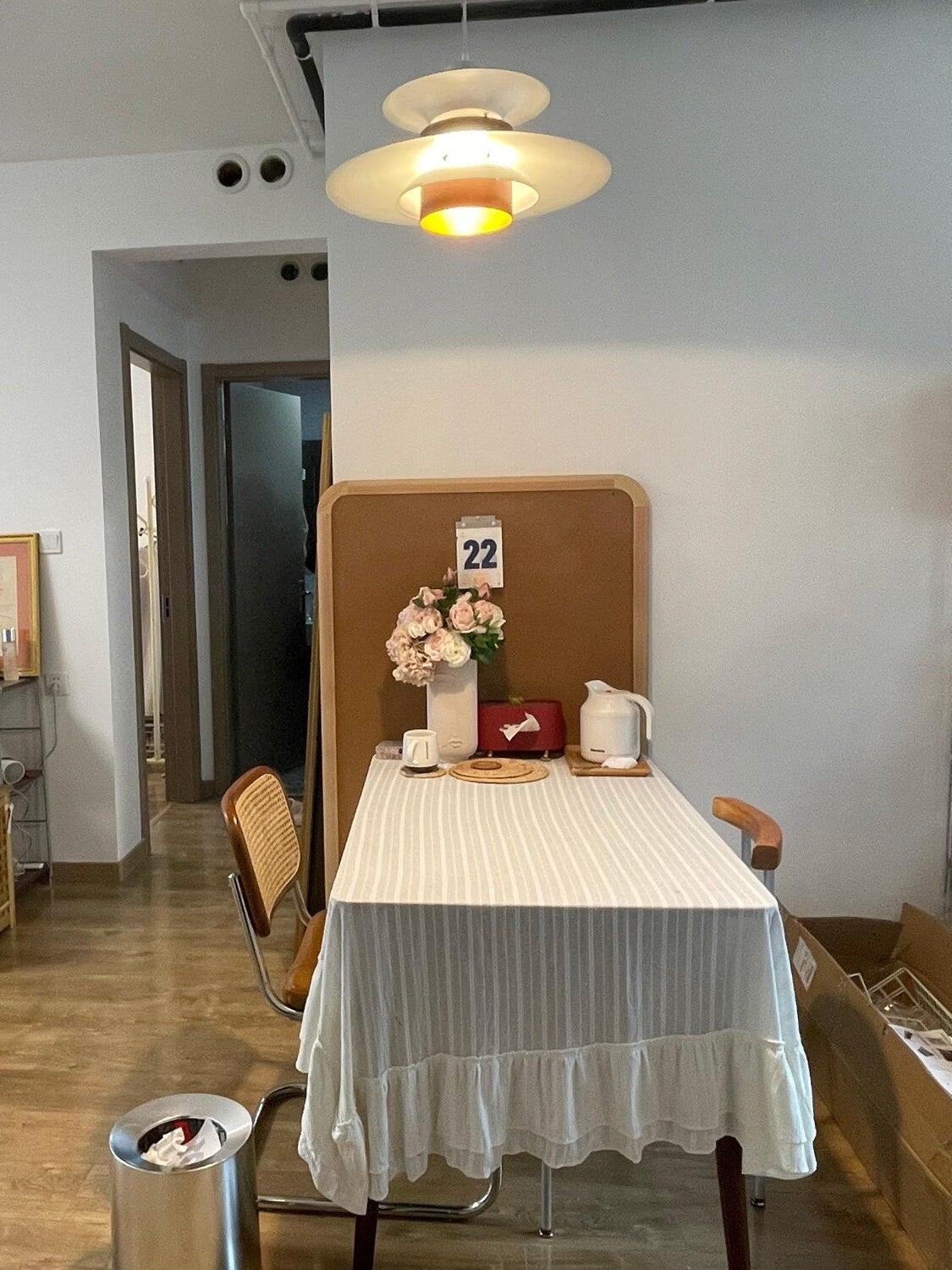 White and wood pendant over a covered dining table