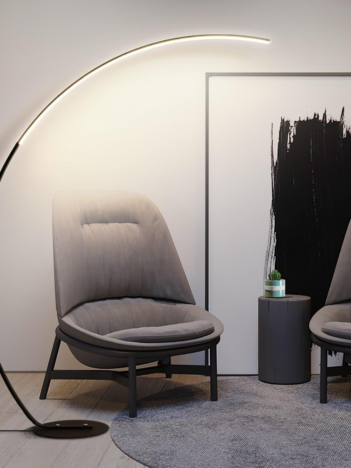 Black arc light spanning grey lounge chair