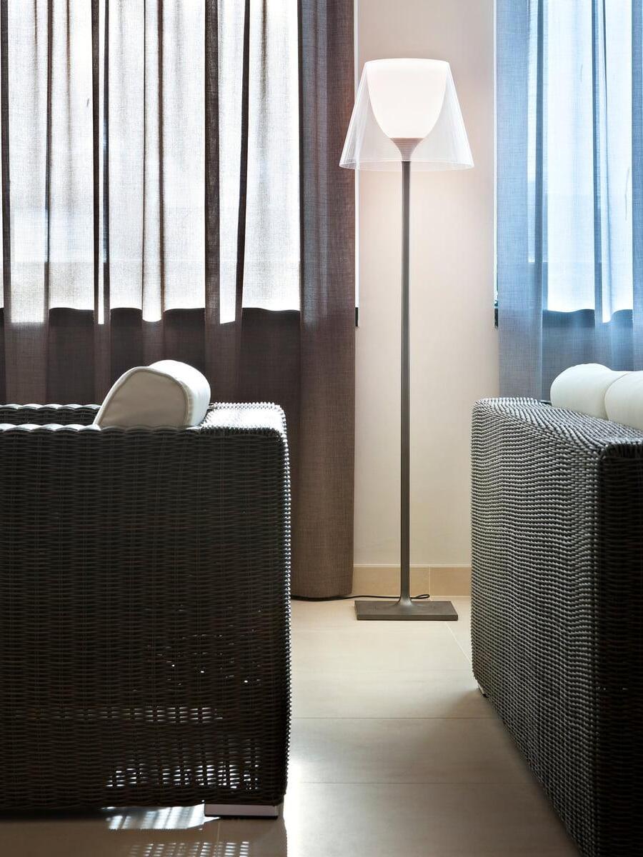 Ktribe clear floor lamp between chairs