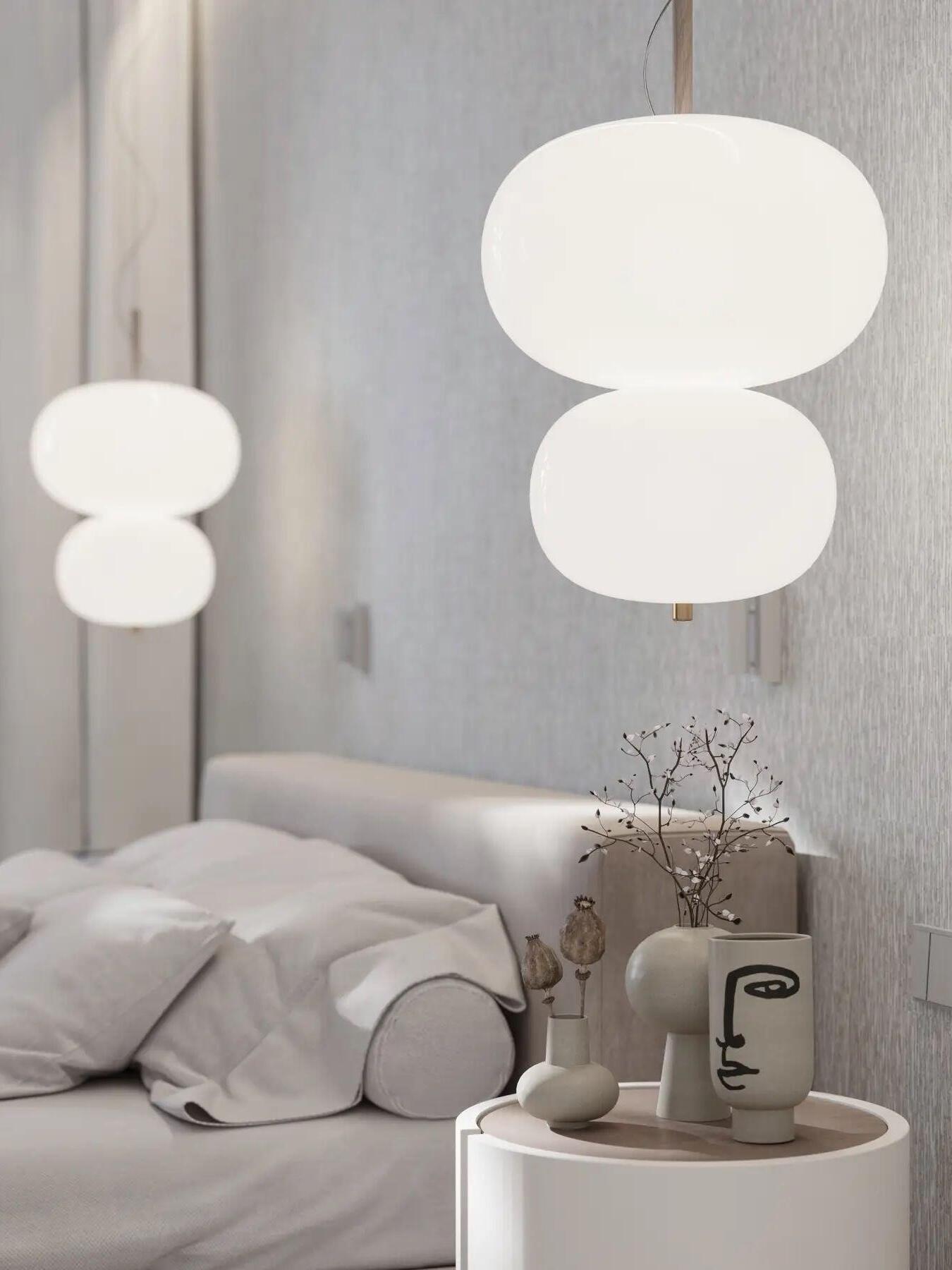 Two-globe pendants beside an upholstered bed
