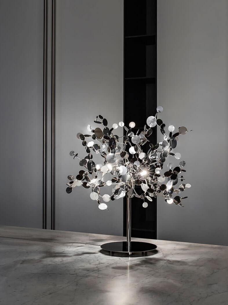 Silver disc table lamp on a slim stem and circular base