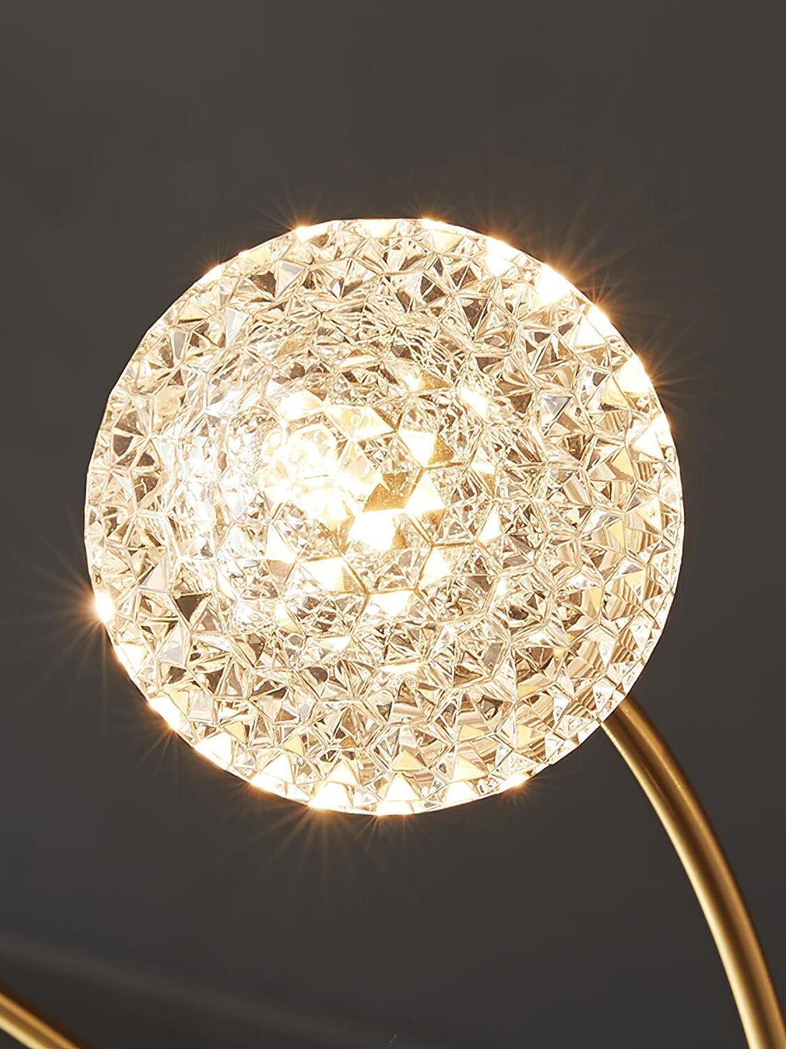 Close view of a glowing glass globe with a geometric star-like pattern on a curved brass-tone arm