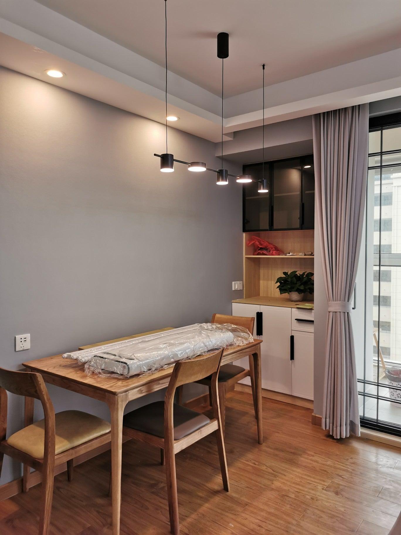 Black cylinder and disc lights beside a curtain