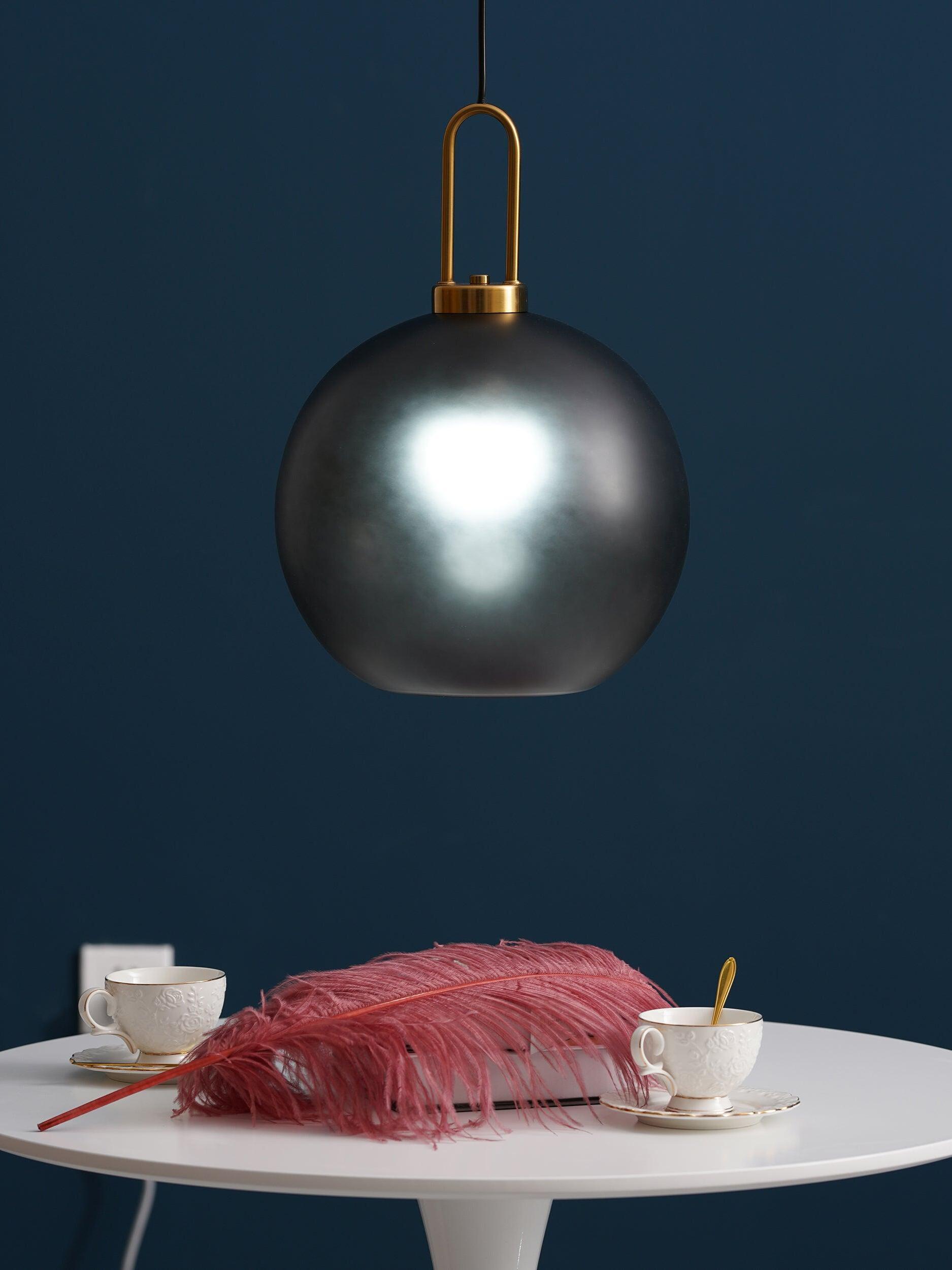 Dark globe pendant and loop fitting against a blue wall