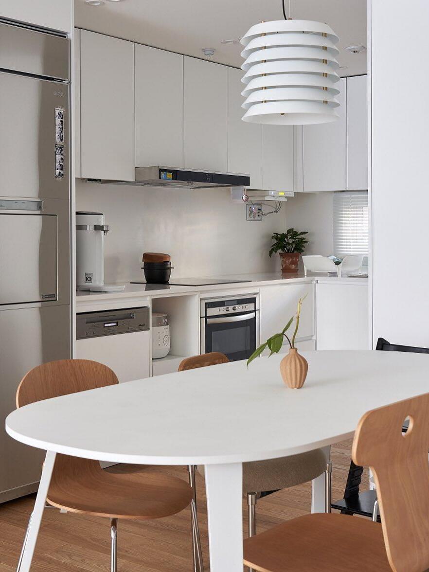 White stacked pendant above round white table in bright kitchen