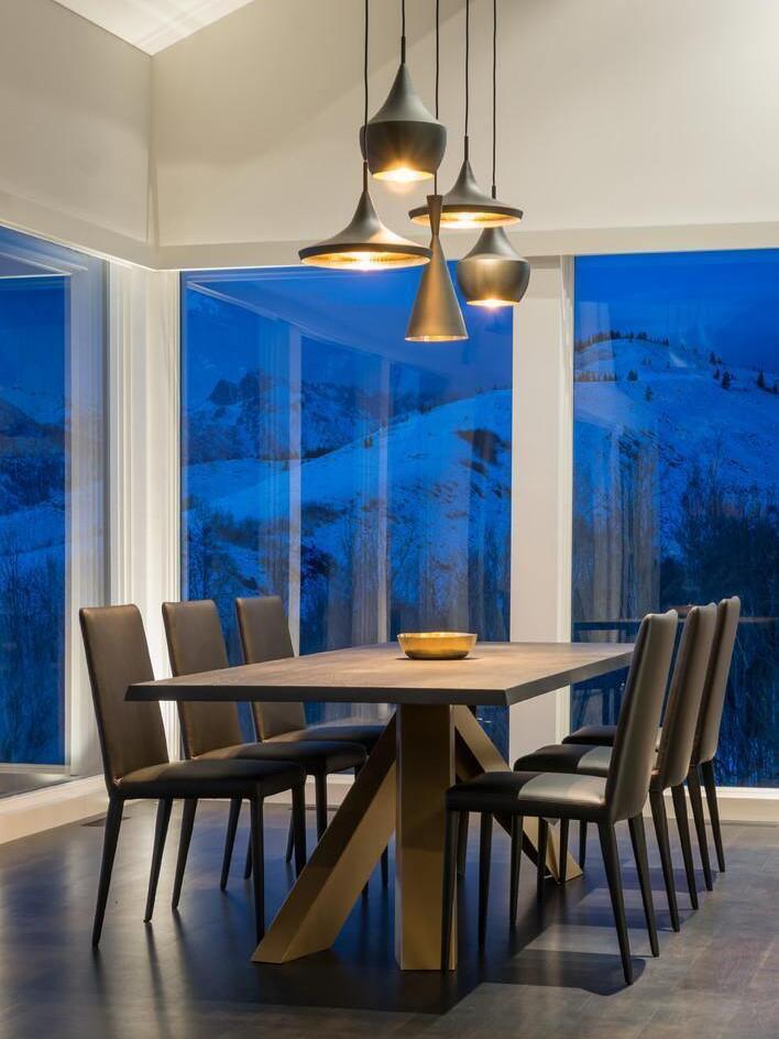 Mixed pendant shapes beside dining-room windows