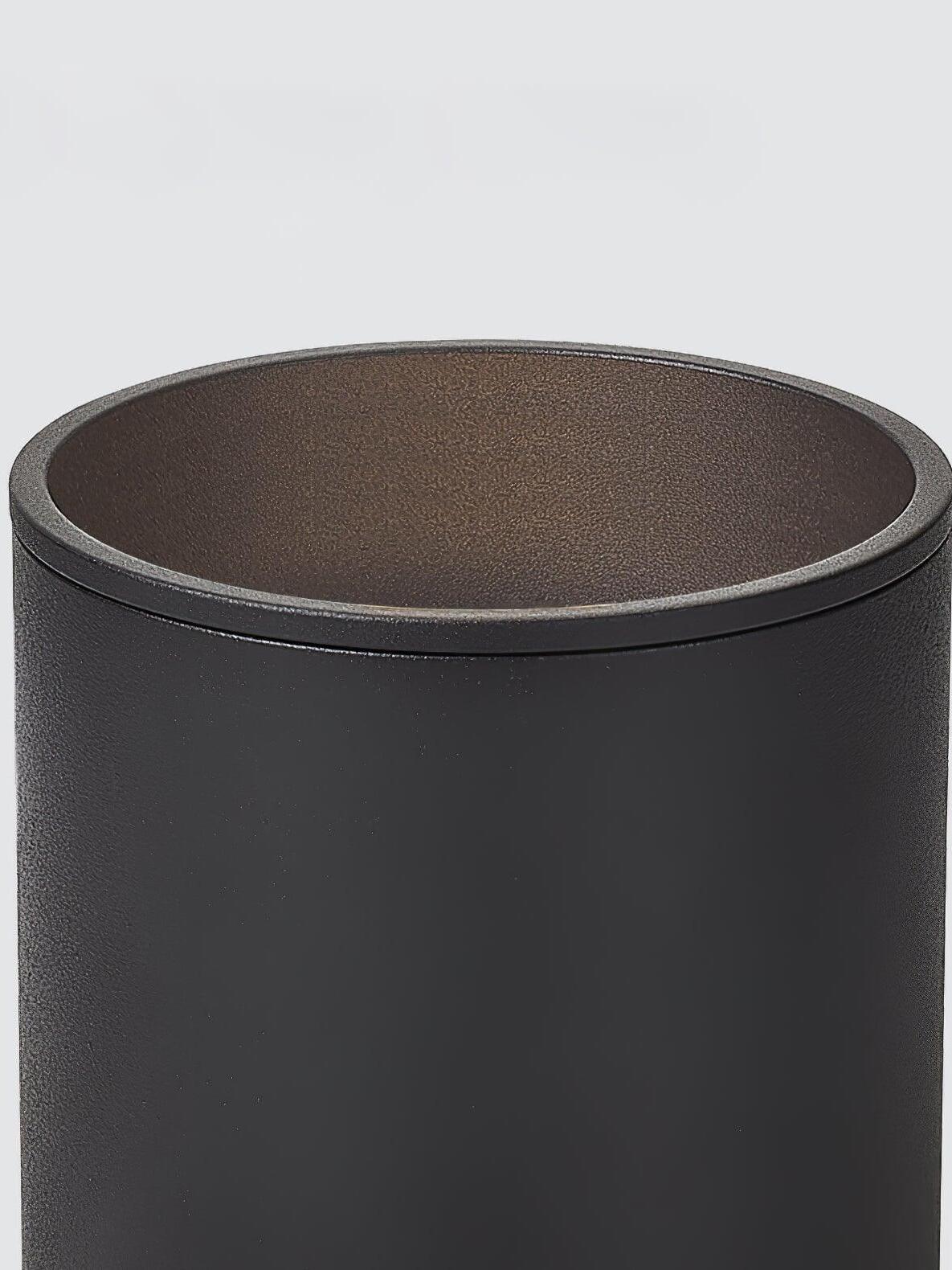 Close black cylindrical housing rim and textured inner surface, with the optic outside the crop