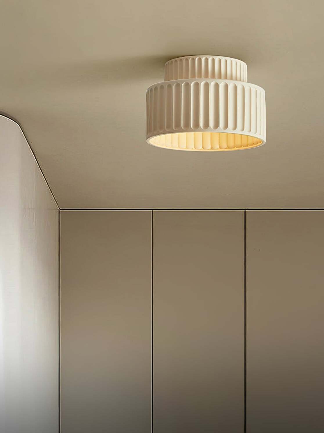 Beige ribbed ceiling lamp near built-in cupboards