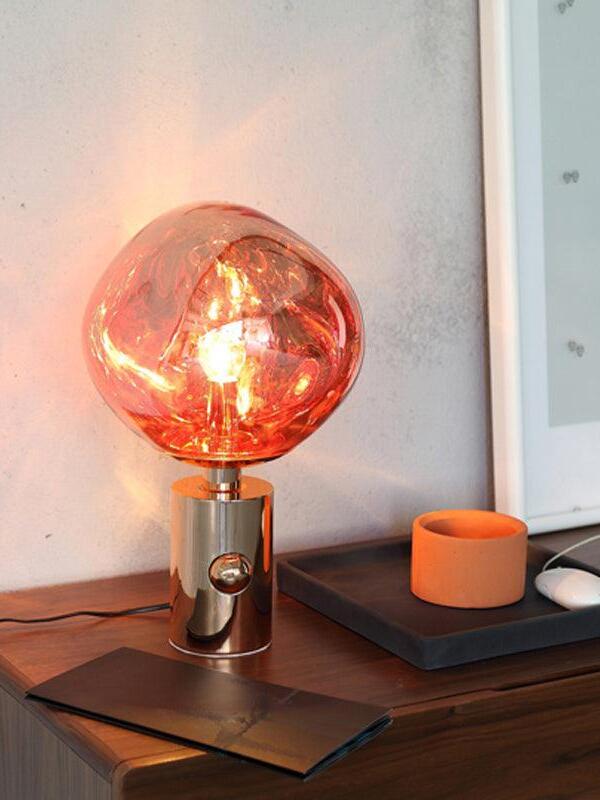 Reflective rounded table lamp beside a cup