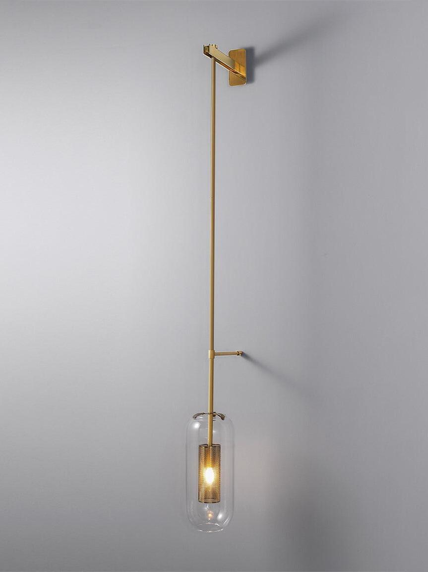Gold-tone vertical fixture with a slim side support and illuminated glass shade on a gray wall