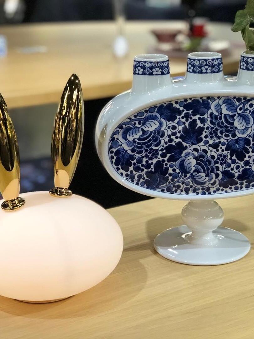 Cropped glowing rabbit beside blue-and-white patterned vase