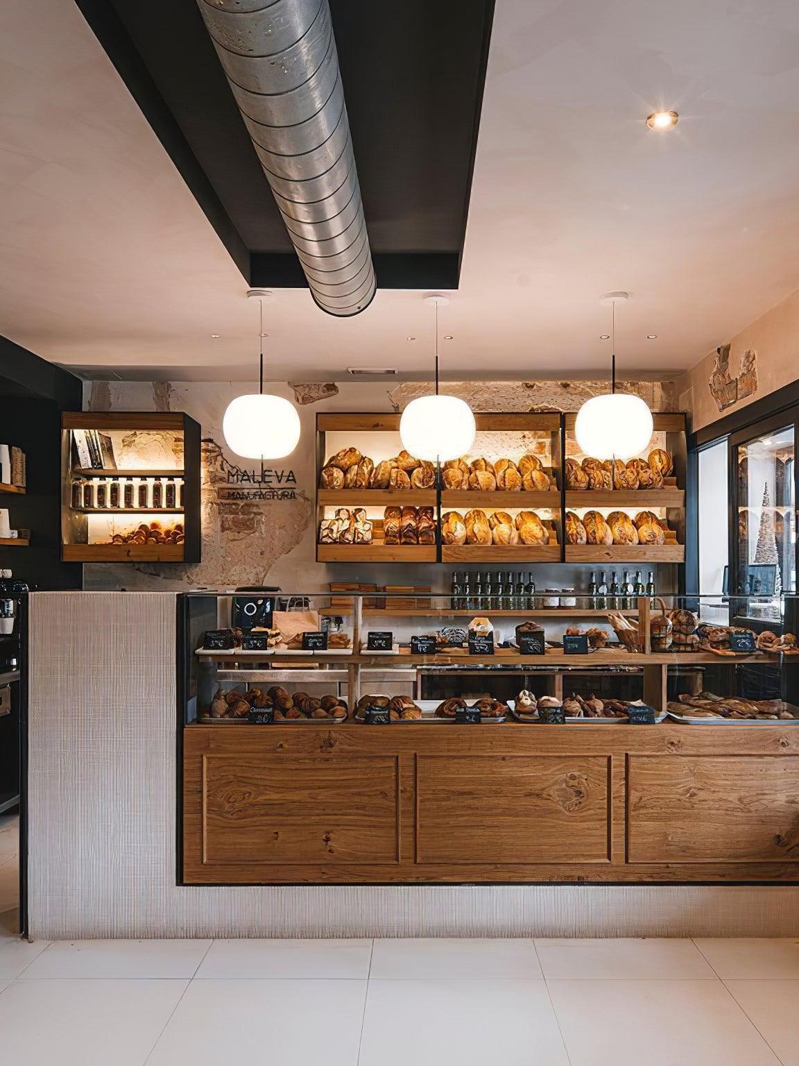 Rounded white pendants above a cafe display counter