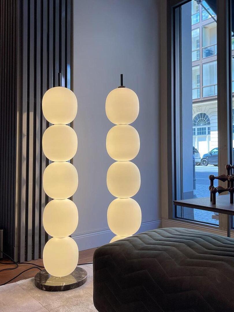Two illuminated globe columns near window