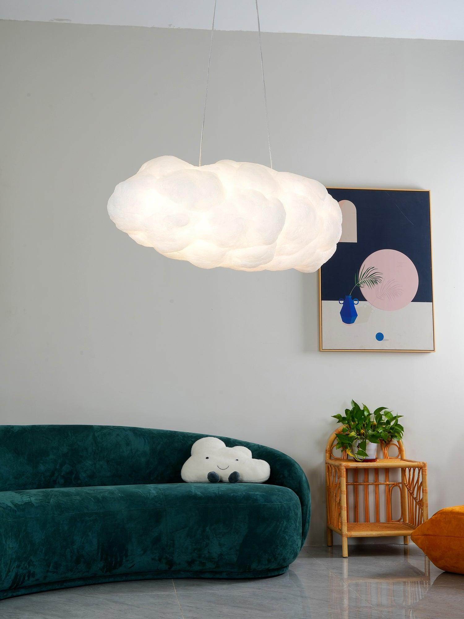 Lit cloud pendant above a green curved sofa