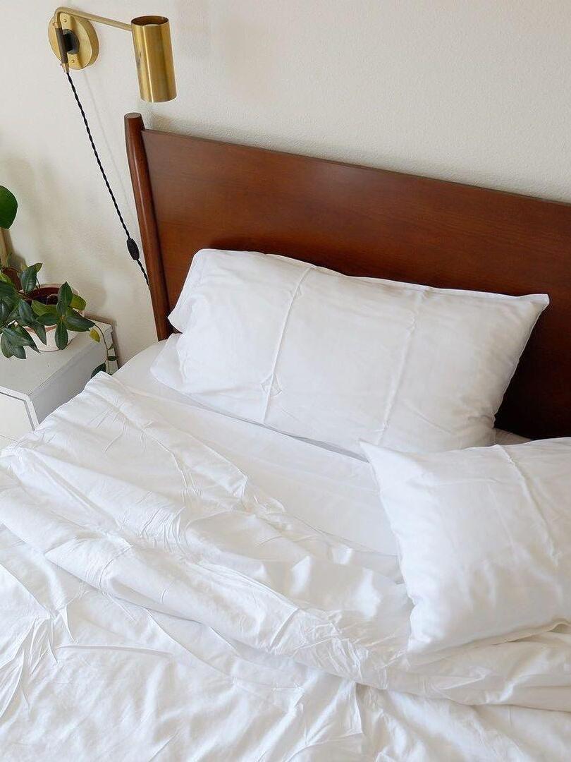 Closer view of brass-tone bedside light and exposed cord