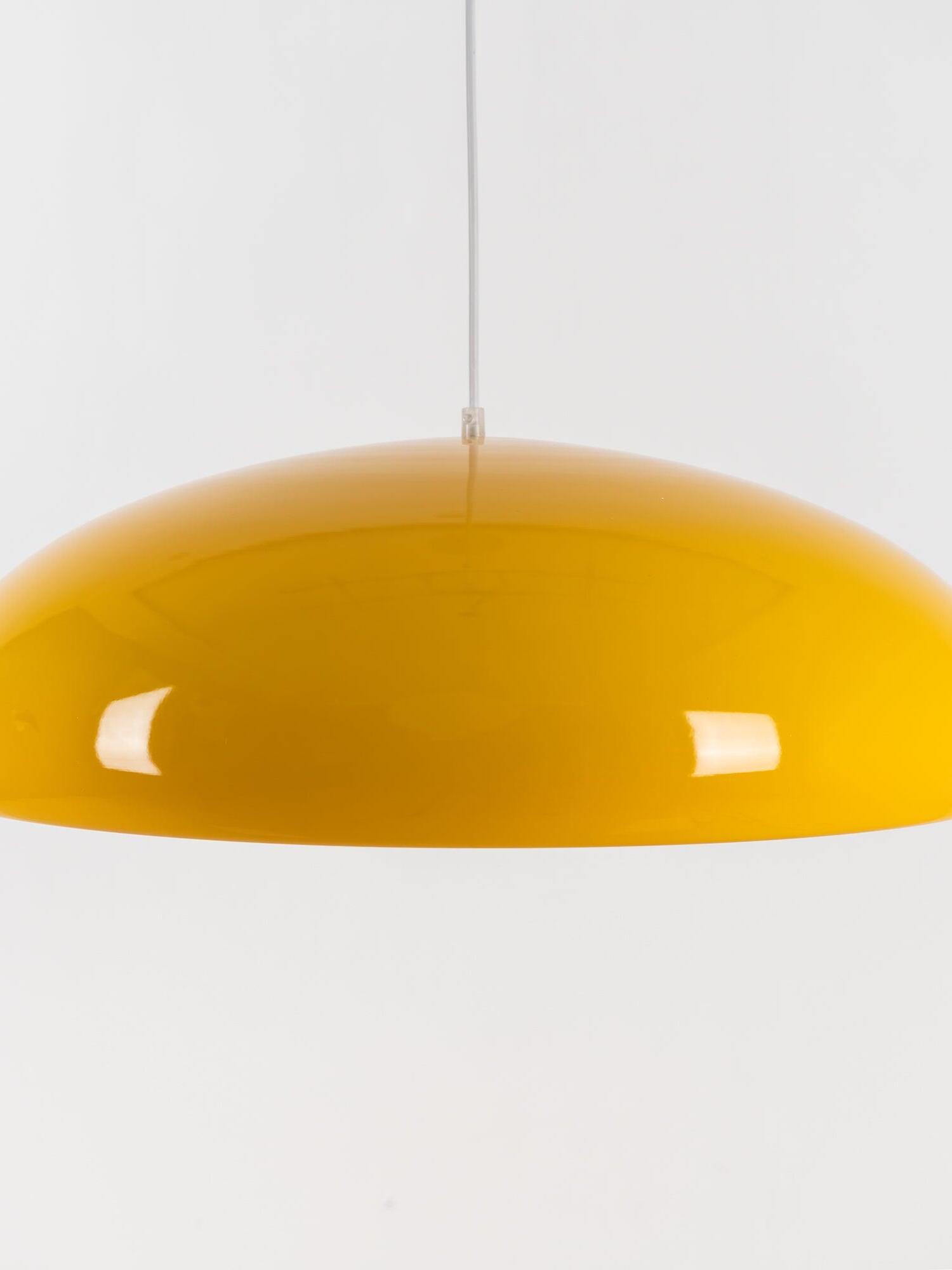 Glossy yellow dome shade with reflections across its curved surface