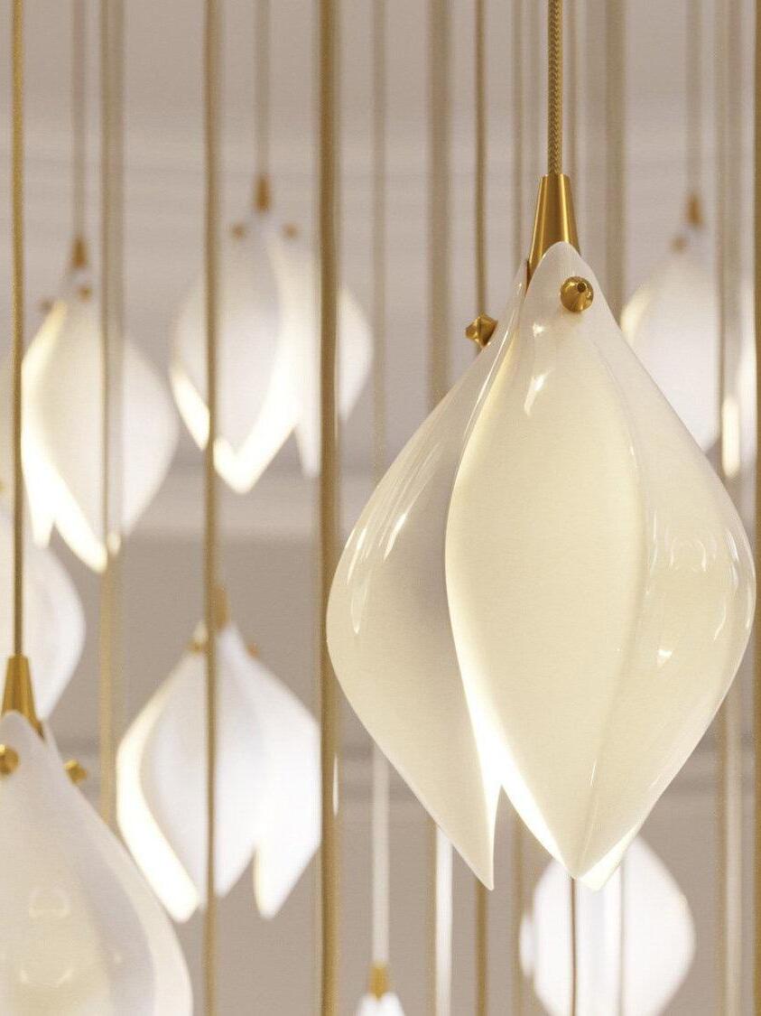 Close-up of glowing white curved petals and small gold-coloured upper fittings