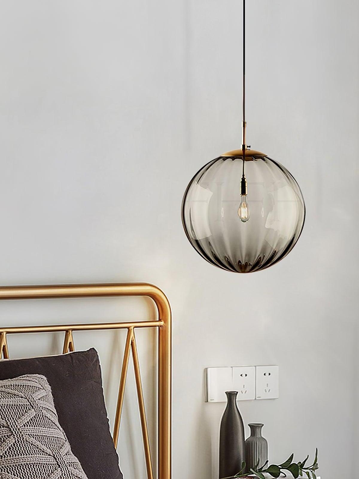 Smoke gray fluted globe beside a metal bed frame