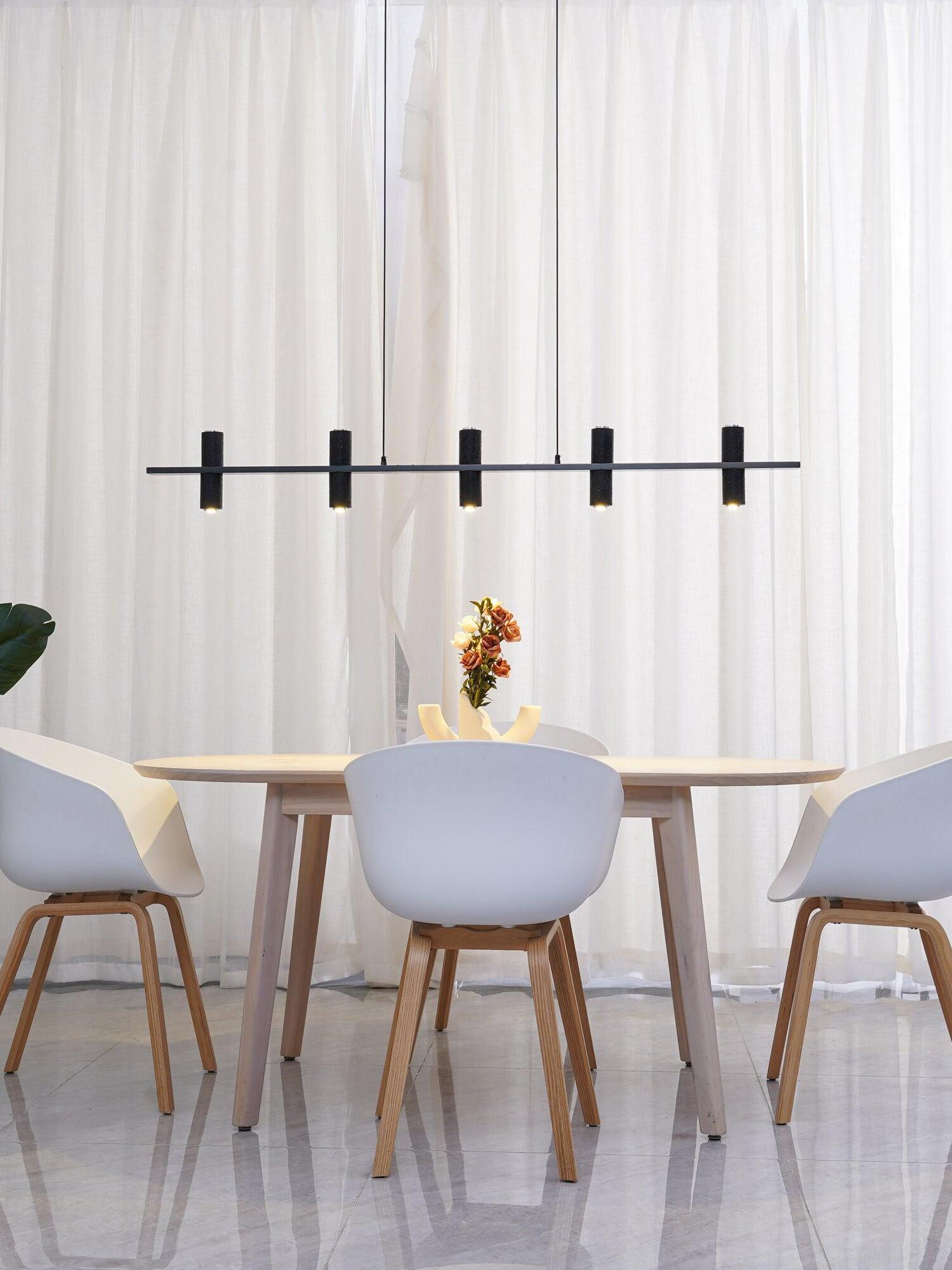 Black cylinder pendant above a bright dining table