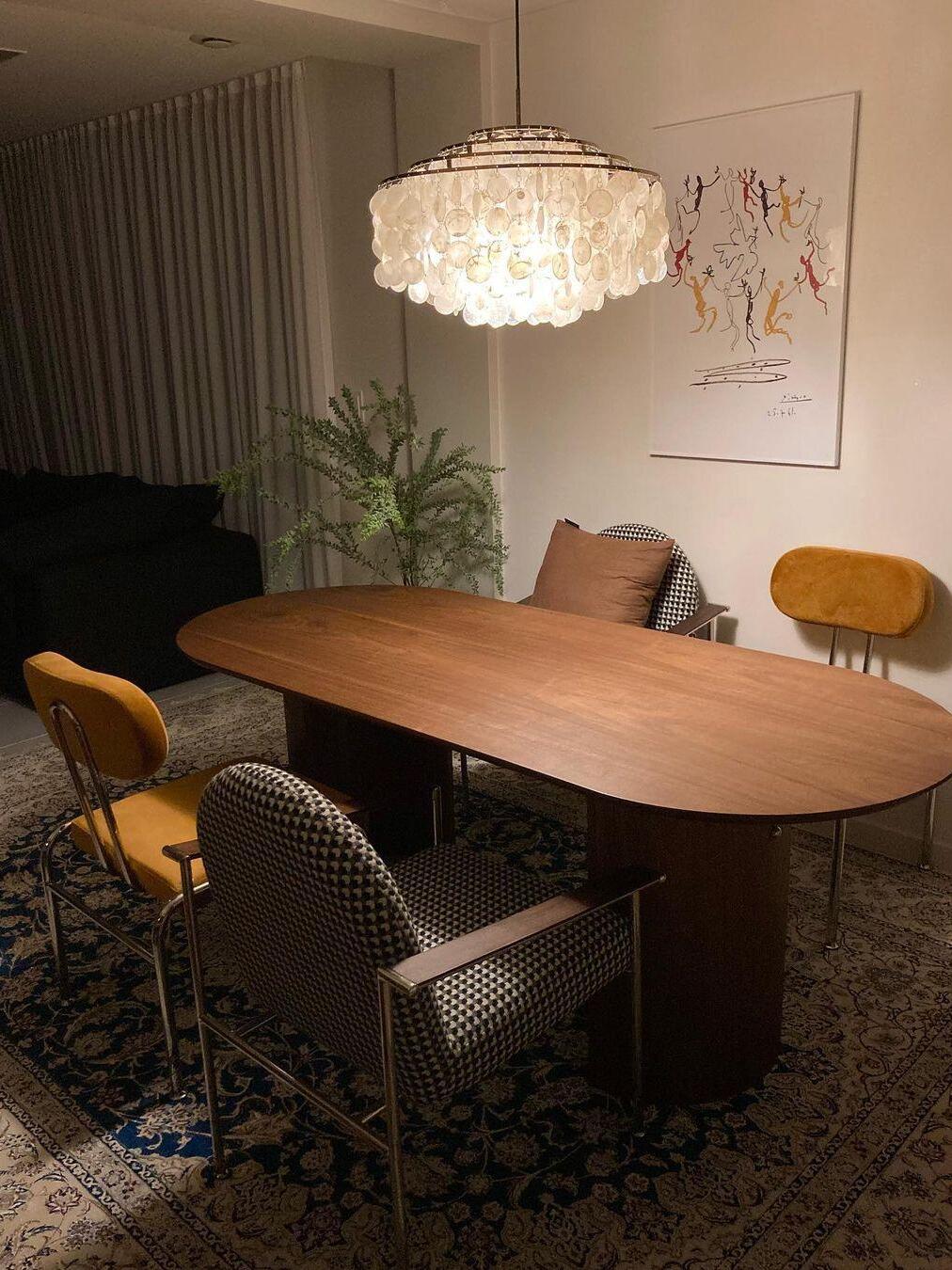 White shell fixture above an oval wooden table