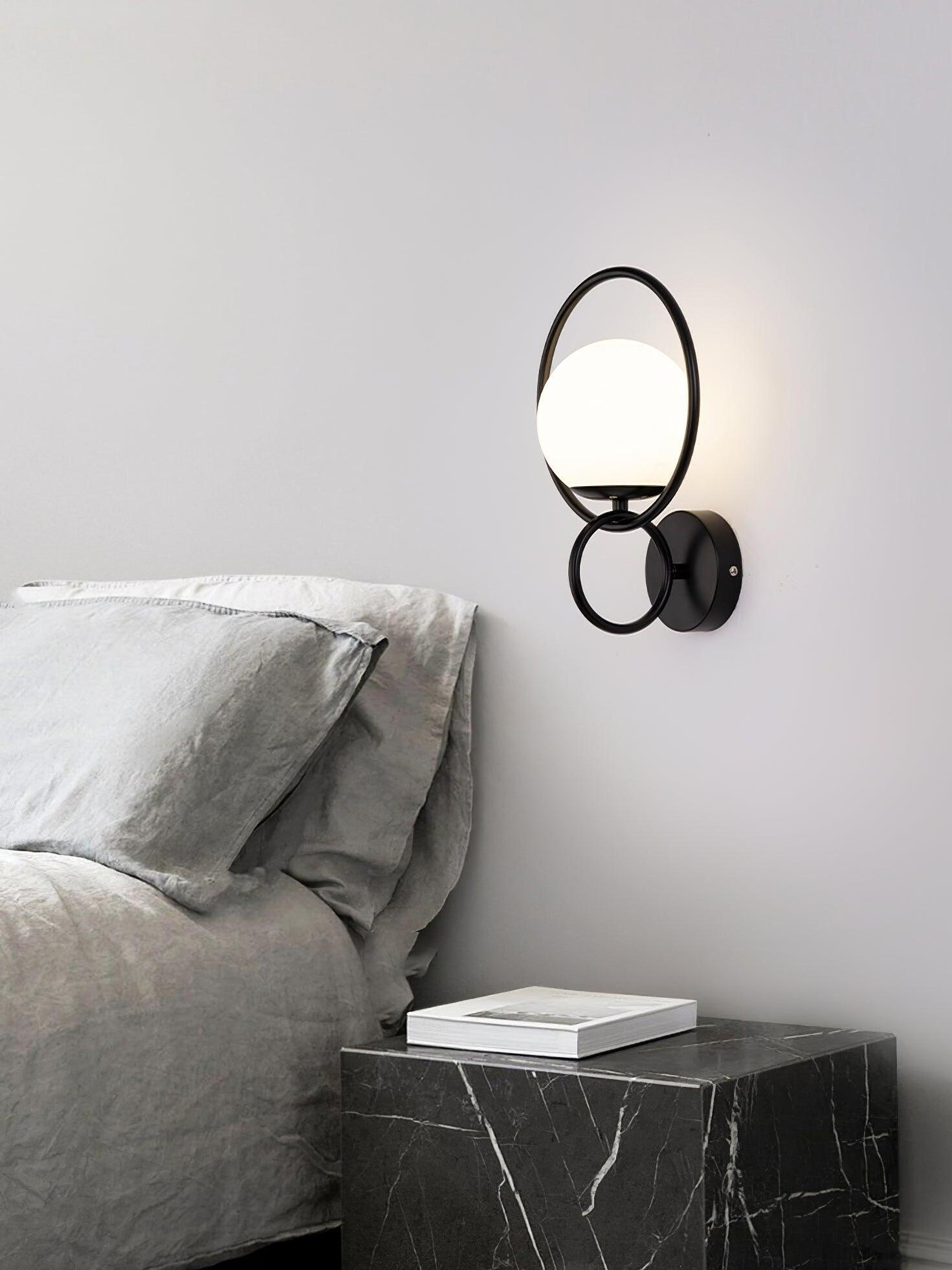 Black ring and white globe light beside bed