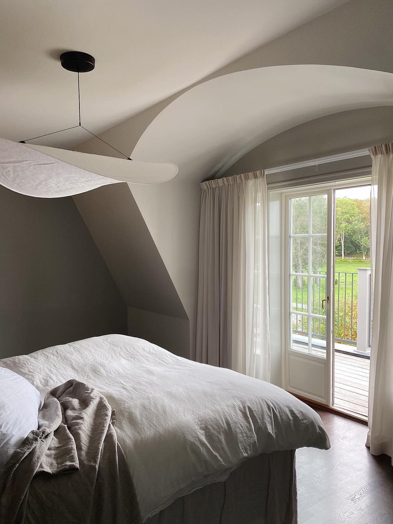 Sweeping white shade in an attic bedroom