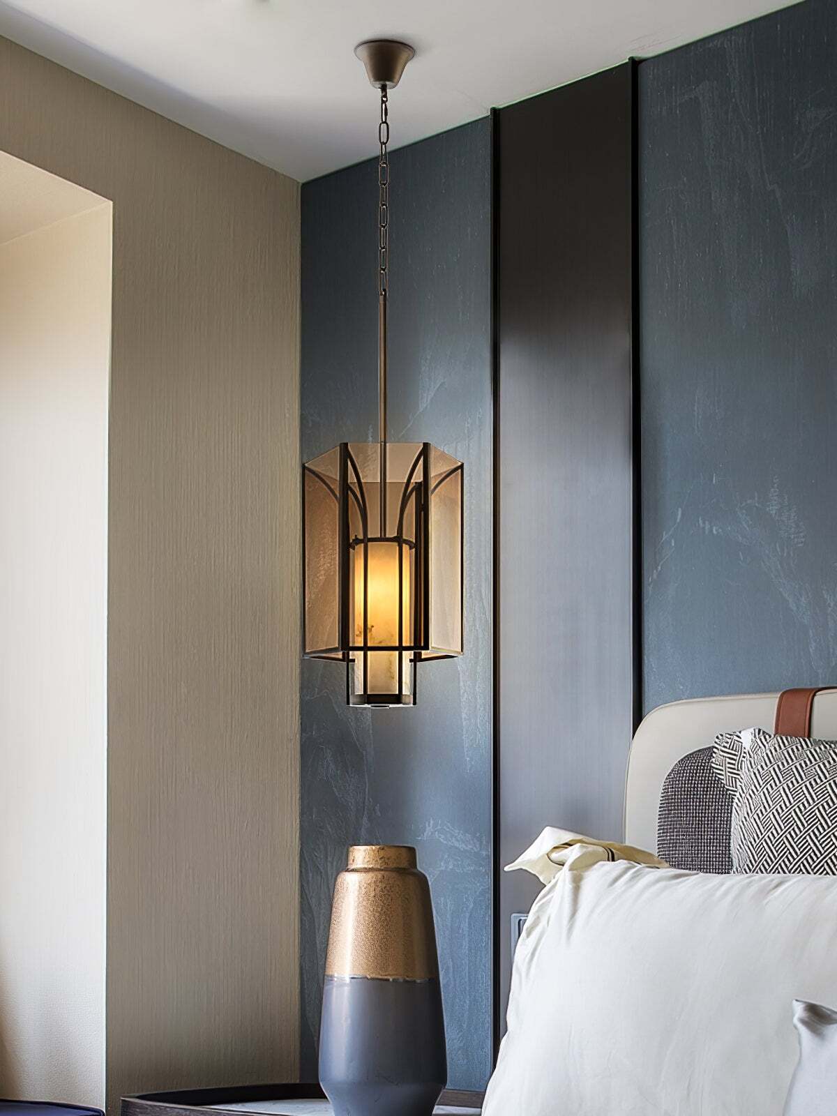 Lit Remy amber lantern pendant beside a bed