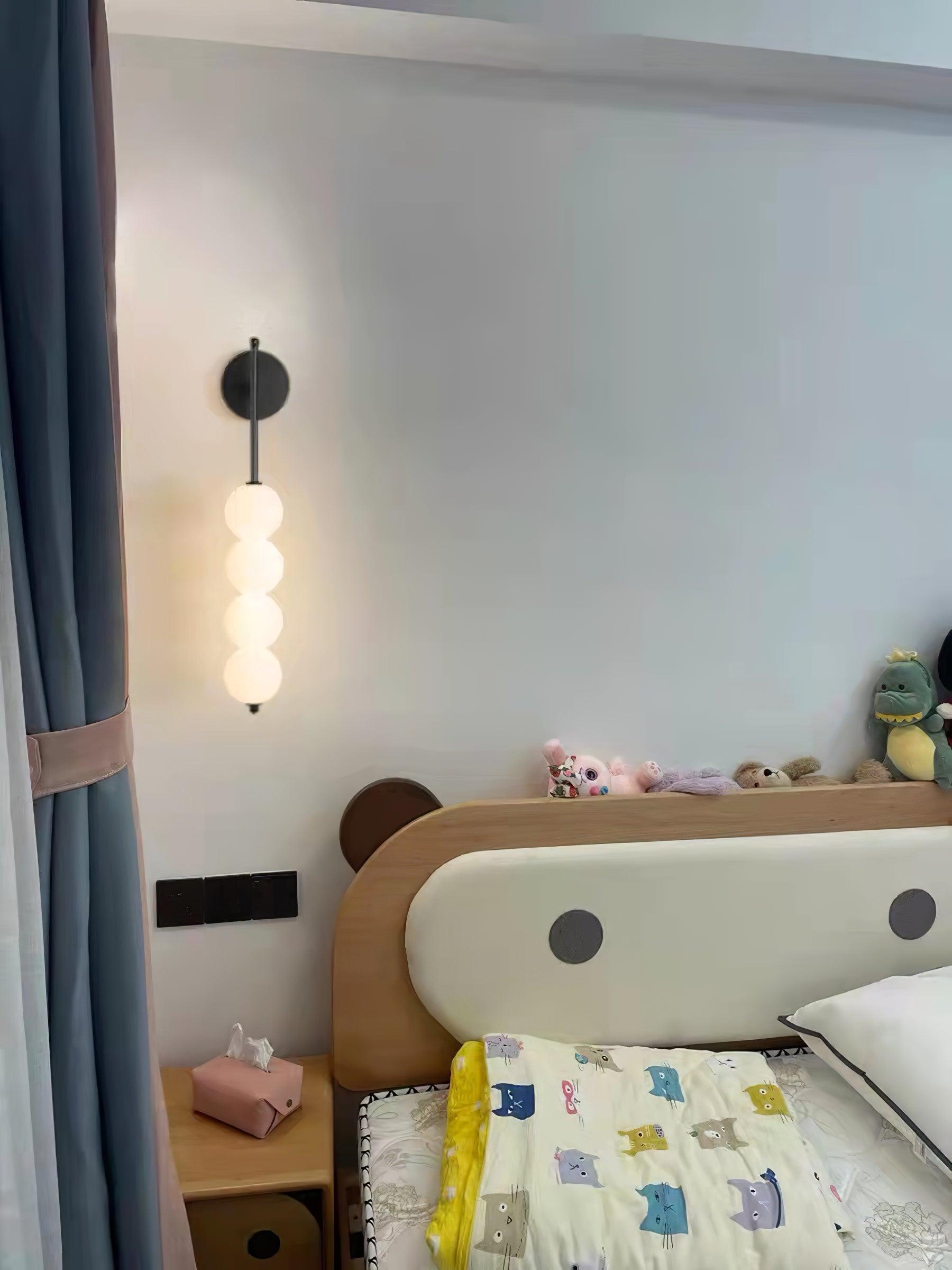 Black stem wall lamp beside a bed and curtains